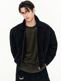 Person wearing a black jacket over a dark shirt on a white background